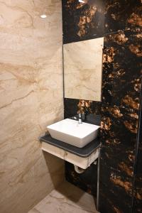 a bathroom with a sink and a mirror at Granotel in kolkata