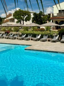 - une piscine avec des chaises longues et des parasols dans l'établissement Résidence Kallisté Porticcio, à Porticcio