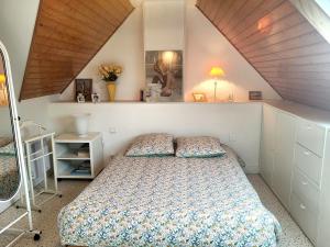 een slaapkamer met een bed op zolder bij Villa front de mer les Cordylines in Saint-Germain-sur-Ay