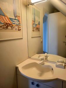 een badkamer met een wastafel en een spiegel bij Villa front de mer les Cordylines in Saint-Germain-sur-Ay +25 foto's