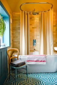 a bathroom with a tub and a chair and a shower at The Dover Stop in Dover +36 photos