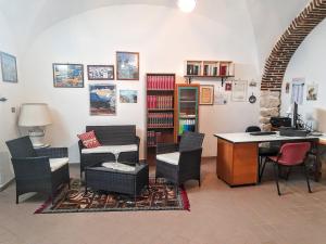 sala de estar con mesa, sillas y escritorio en B&B L'arco Fiorito, en San Gregorio