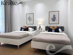 2 bedden in een slaapkamer met witte muren bij Kease Qirwan B-13 Royal touch Patio AX97 in Riyad