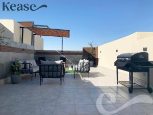 een patio met een grill, stoelen en een tafel bij Kease Qirwan B-13 Royal touch Patio AX97 in Riyad
