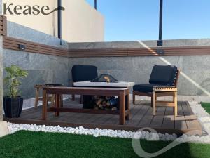 een patio met 2 stoelen, een tafel en een open haard bij Kease Qirwan B-13 Royal touch Patio AX97 in Riyad