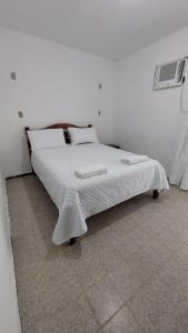 białe łóżko w białym pokoju z: w obiekcie Pousada Terra de Minas w mieście Natal