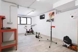 a gym with treadmills and exercise bikes in a room at Le Rose Residence & Bici House in Cattolica