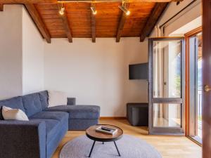 Una sala de estar con un sofá azul y una mesa. en Apartment Superiore by Interhome, en Vercana