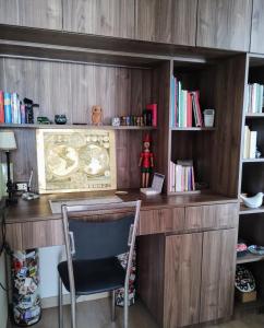 a wooden desk with a chair and a book shelf at Linda habitación baño privado en casa de familia desayuno incluido in Lima