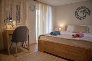 a bedroom with a bed and a desk and a chair at Auntie Katie's house in Giannádes