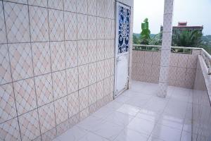- Balcón con puerta y pared de baldosa en Ajieh Rest House, en Douala