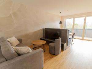 a living room with a couch and a television at Apartment be blue by Interhome in Mieming