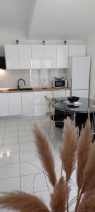 a kitchen with white cabinets and a table and chairs at Apartmani Antunović Podgora in Podgora