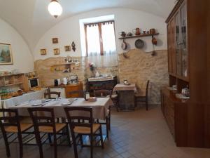 comedor con mesas y sillas y cocina en B&B L'arco Fiorito, en San Gregorio