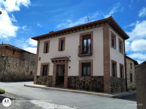 Edificio blanco y marrón con balcón en Casa Rural Casa Jacinta, en San Cristóbal de Segovia