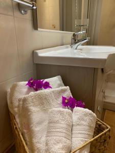 uma casa de banho com toalhas numa cesta ao lado de um lavatório em Affitti brevi Tzia Licca em Teulada