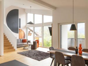 a dining room and living room with a table and chairs at Apartment be home by Interhome in Mieming