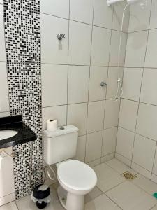 a white bathroom with a toilet and a shower at Casa da Vó Maria Suite Dupla 09 in Goiânia