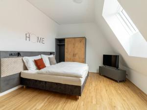 a bedroom with a bed and a television at Apartment be home by Interhome in Mieming