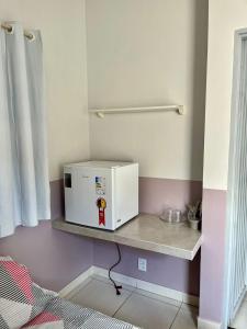 a microwave sitting on a shelf in a room at Casa da Vó Maria Suite Dupla 09 in Goiânia