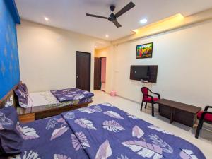 een slaapkamer met 2 bedden en een tv. bij Nirmal Luxury Rooms in Garudeshwar