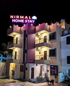 een gebouw met een bord dat readsnirla home stay bij Nirmal Luxury Rooms in Garudeshwar