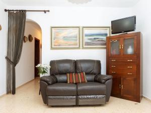 a leather couch in a living room with a television at Holiday Home Villa Paloma by Interhome in Peñíscola