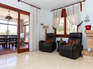 a living room with two chairs and a fireplace at Holiday Home Villa Paloma by Interhome in Peñíscola +24 photos