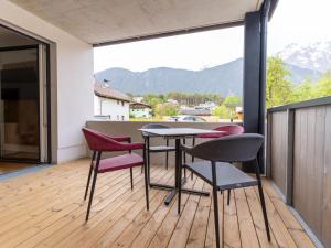 a table and chairs on a balcony with a view of mountains at Apartment be magic by Interhome in Mieming