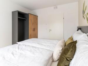 a bedroom with two white beds and a wooden cabinet at Apartment be hopeful by Interhome in Mieming +17 photos
