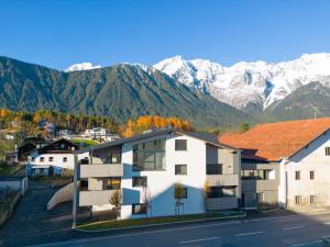 a building with snow capped mountains in the background at Apartment be magic by Interhome in Mieming