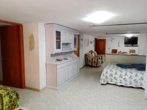 1 dormitorio con 1 cama y cocina con encimera en TITI' appartamento vacanze La Corte, en Campanedda