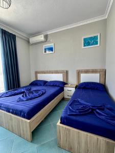 2 camas en un dormitorio con sábanas azules en Eri Apartments 2, en Shëngjin
