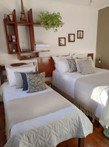 a bedroom with two beds with white sheets at Hospedaria Canto do Vinhedo in Espirito Santo Do Pinhal