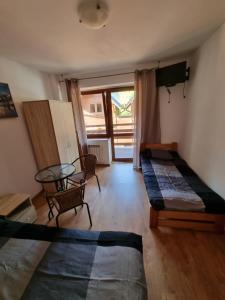 a room with two beds and a table at Pensjonat pod Dębami in Pobierowo