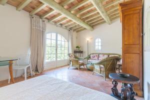 a bedroom with a bed and chairs and a table at Orangerie in Bonnieux