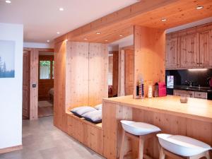 a kitchen with wooden walls and a counter with stools at Apartment Jade 22 by Interhome in Villars-sur-Ollon