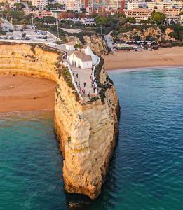 an island in the ocean with a beach and buildings at Casa à Porta do Torreão in Silves