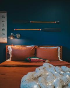 a bed with a baseball bat on a blue wall at Willow Pond Motel in Catskill