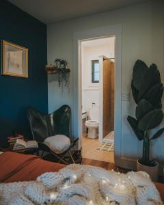 a bedroom with a bed and a chair and a bathroom at Willow Pond Motel in Catskill