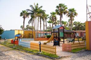 a playground with a slide and a swing at VOI Vila do Farol Resort in Santa Maria