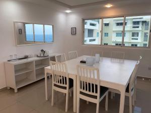 a dining room with a white table and chairs at Escape Oceanfront Condo in Avenida Espana w/Pool in Santo Domingo