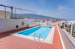 a swimming pool on the roof of a building at Céntrico apartamento con vista al muelle in Puerto de la Cruz
