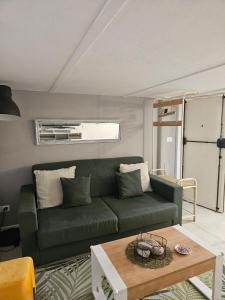 uma sala de estar com um sofá verde e uma mesa em CASA DI MAGGIE em Sanremo