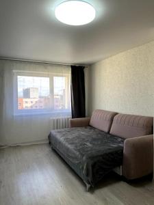 a living room with a couch and a window at Однокомнатная квартира с новым ремонтом in Ahtme