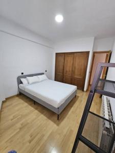 ein Schlafzimmer mit einem weißen Bett und einer Leiter in der Unterkunft Piso junto al Madrid Río in Madrid