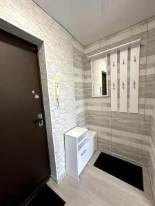 a bathroom with a shower and a door and a sink at Однокомнатная квартира с новым ремонтом in Ahtme