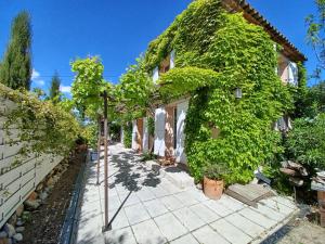 eine Außenansicht eines Hauses mit Efeu darauf in der Unterkunft Maison climatisée en campagne, terrasses couvertes grand jardin ombragé et piscine in Aix-en-Provence
