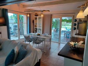 ein Wohnzimmer mit einem Tisch und einem Sofa in der Unterkunft Maison climatisée en campagne, terrasses couvertes grand jardin ombragé et piscine in Aix-en-Provence