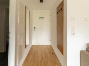 a hallway with white walls and a wooden floor at Apartment be calm by Interhome in Mieming
